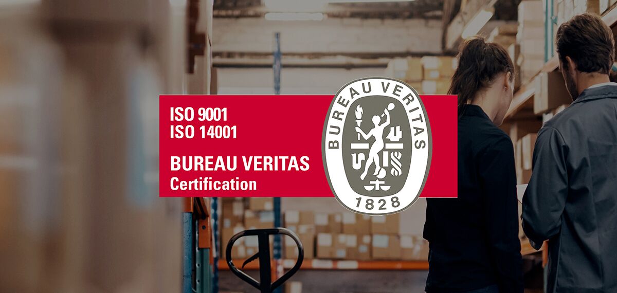 ISO Standard logo in front of people surrounded by boxes in the warehouse.